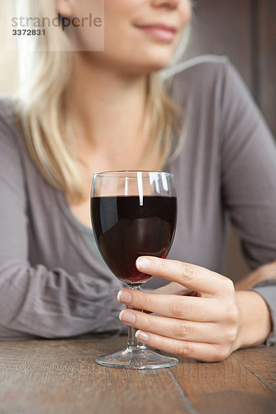 Junge Frau mit Rotwein in der Bar
