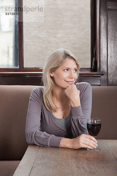 Junge Frau in der Bar mit Rotwein