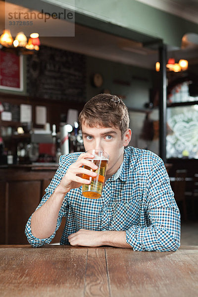 Junger Mann trinkt Bier