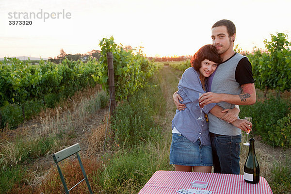 Paar in einem Feld mit Tisch und Wein