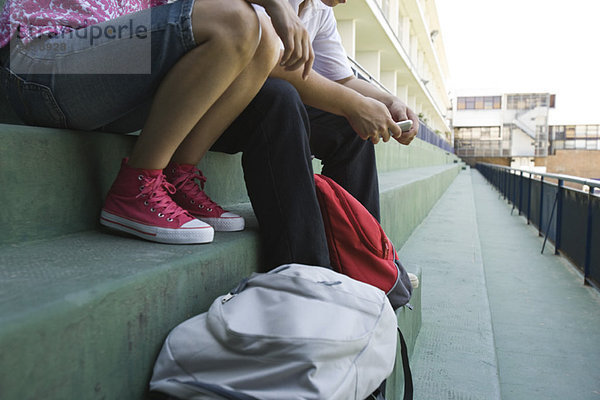 Teenager sitzen zusammen auf Stufen  niedriger Abschnitt