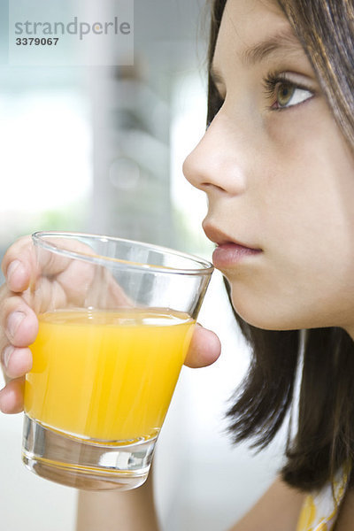 Mädchen trinken ein Glas Orangensaft