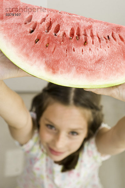 Mädchen hält Scheibe Wassermelone hoch