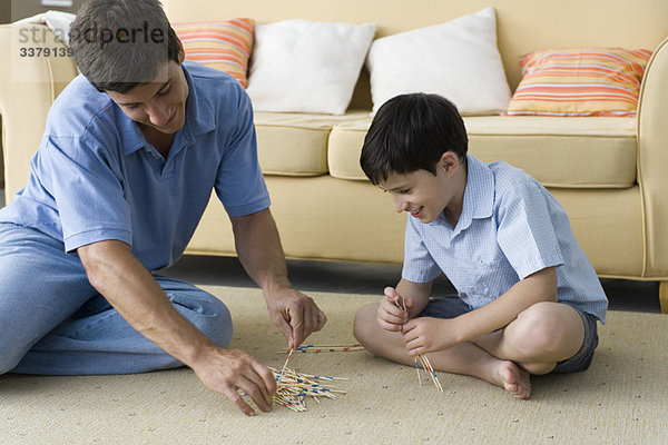 Vater und Sohn beim Spielen von Pick-Up-Stöcken