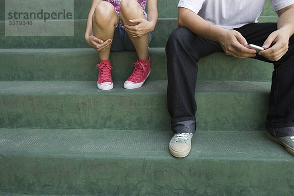 Teenager-Paar auf einer Treppe sitzend