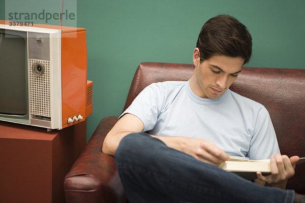 Junger Mann entspannt mit Buch