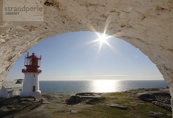 Blick durch einen Bogen auf eine Küste mit Leuchtturm  Norwegen  Erhöhte Ansicht
