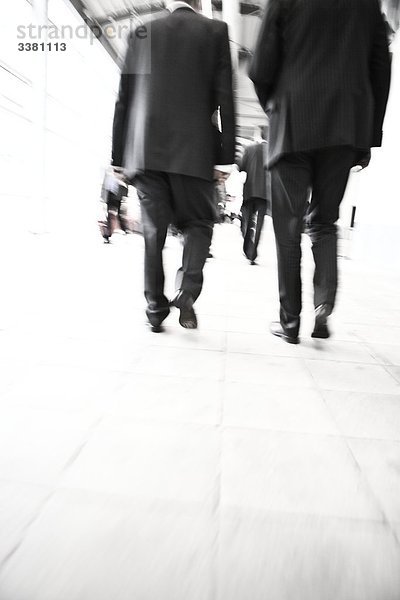 Geschäftsmänner laufen auf einem Bürgersteig  Flachwinkelansicht