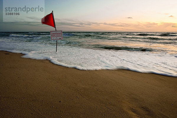 Rote Fahne und Warnschild an der Nordseeküste  Rantum  Sylt  Deutschland