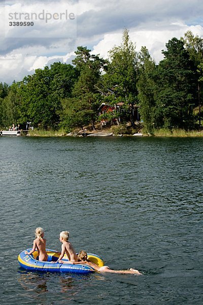 Drei Kinder in einem Schlauchboot  Schweden.