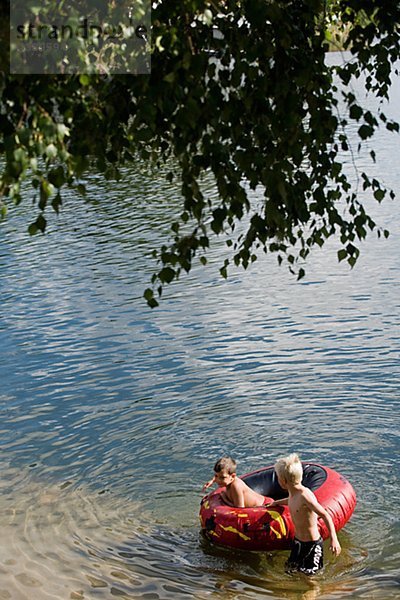 Zwei Jungs spielen mit einem Gummi-ring im Wasser  Schweden.