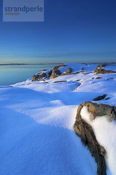 Schnee auf Klippe durch den Ozean