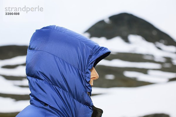 Eine Frau in einem blauen gesteppte Daunenjacke  Lappland  Schweden.