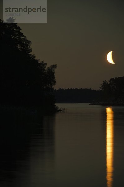Ein Mond spiegelt sich auf der Oberfläche des Wassers  Schweden.