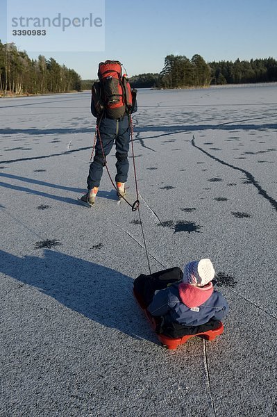 Mann mit einem Kind in ein wenig Schlitten  Schweden.