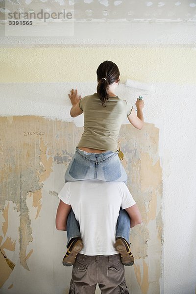 Junges Paar malt Wand
