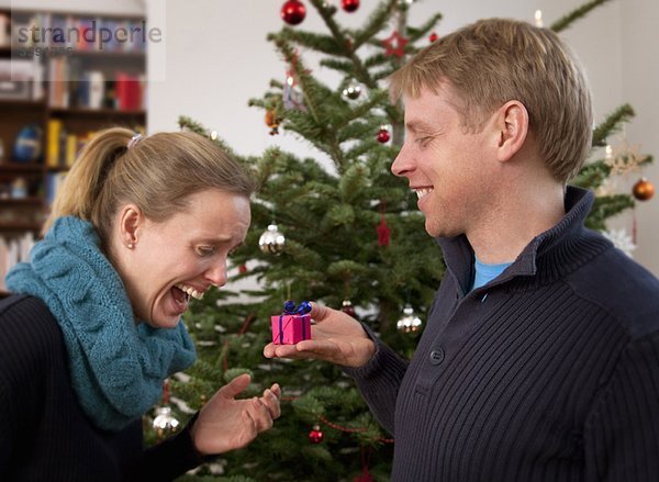 Mann schenkt Frau kleines Weihnachtsgeschenk
