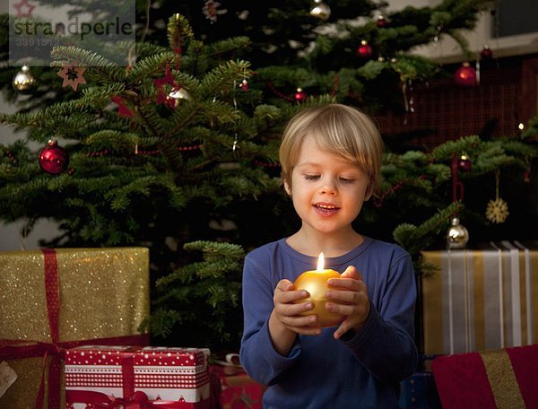 Junge mit Kerze an Weihnachten