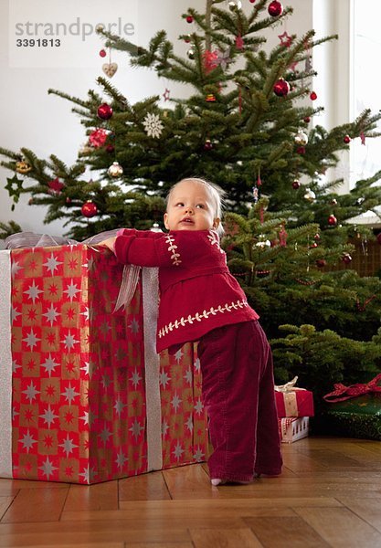 kleines Mädchen mit großem Weihnachtsgeschenk