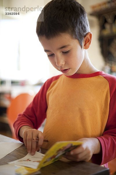 kleiner Junge beim Lesen  Zeichnen im Buch