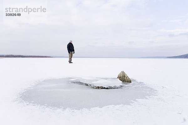 Mann auf gefrorenem See