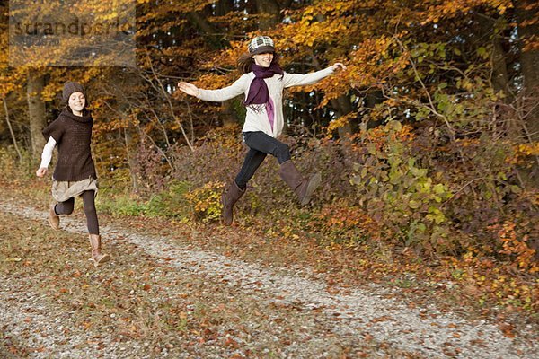 Zwei Mädchen laufen und springen