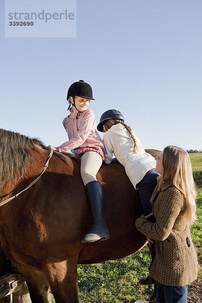 Frau hilft Mädchen zu Pferd