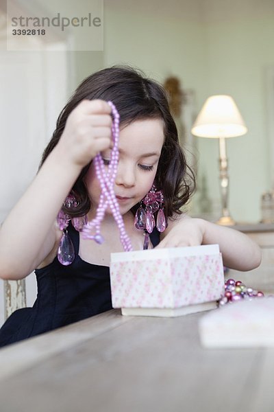 kleines Mädchen spielt mit Schmuck