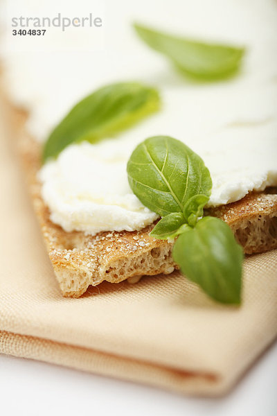 Knäckebrot mit Frischkäse und Basilikum  Close-up