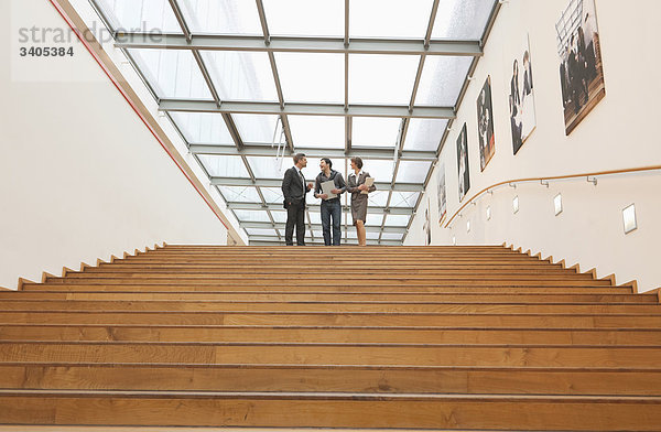 Drei Geschäftsleute gehen die Treppe hinunter