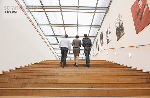 Drei Geschäftsleute gehen die Treppe hinauf