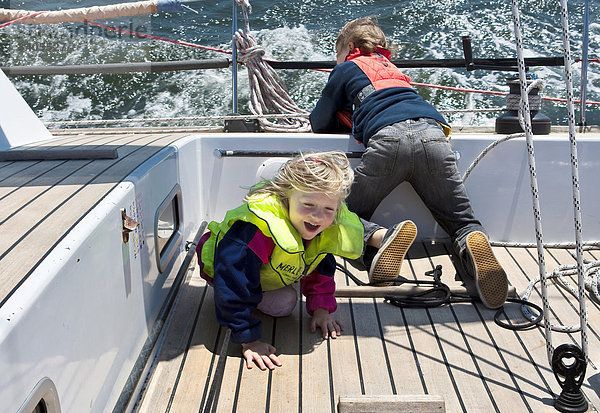 Junge und Mädchen spielen auf einer Segelyacht  Erhöhte Ansicht