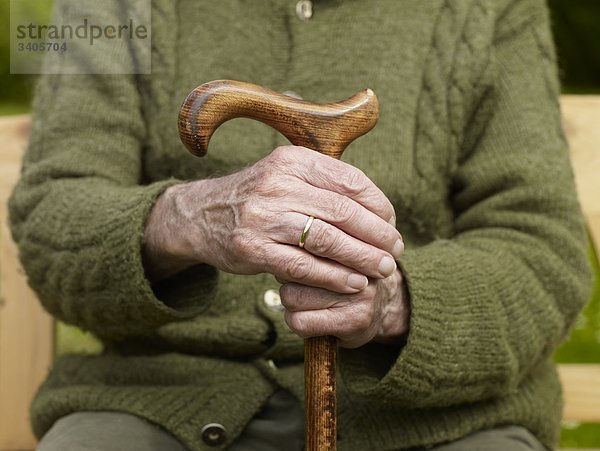 Senior hält Hände an Stock  close-up
