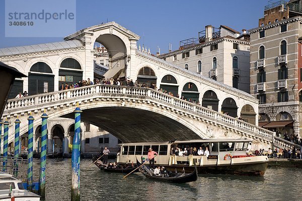 Touristenboot und Gondeln unter der Rialtobrücke auf dem Canale Grande  Venedig  Italien