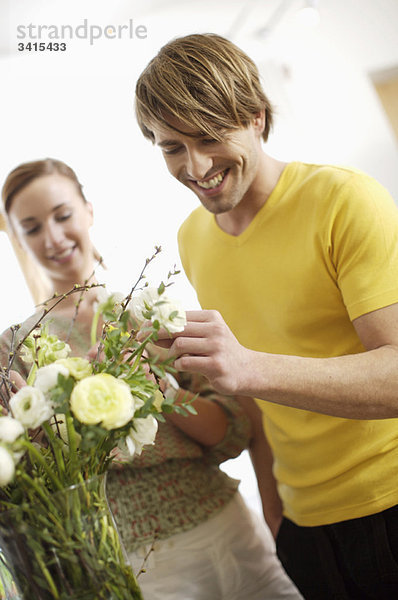 Junges Paar  das Blumen arrangiert