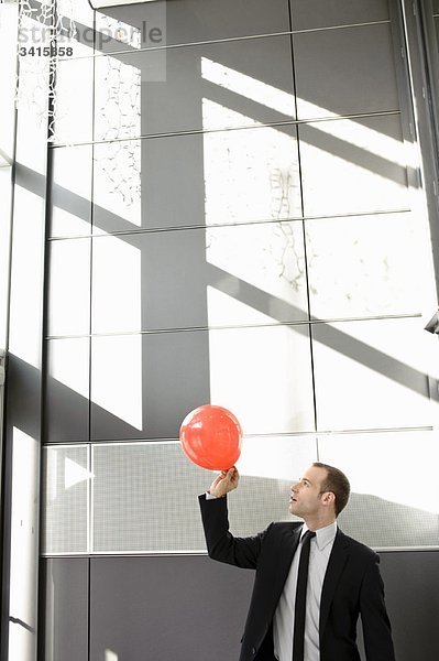 Mann setzt Ballon im Büro frei