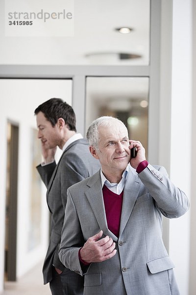 2 Geschäftsleute sprechen auf dem Handy