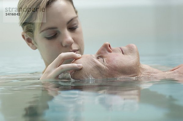 Frau erhält Massage im Pool