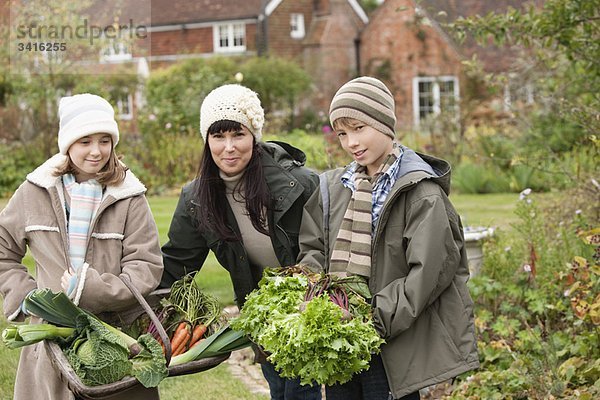 Familie pflückt Gemüse im Garten