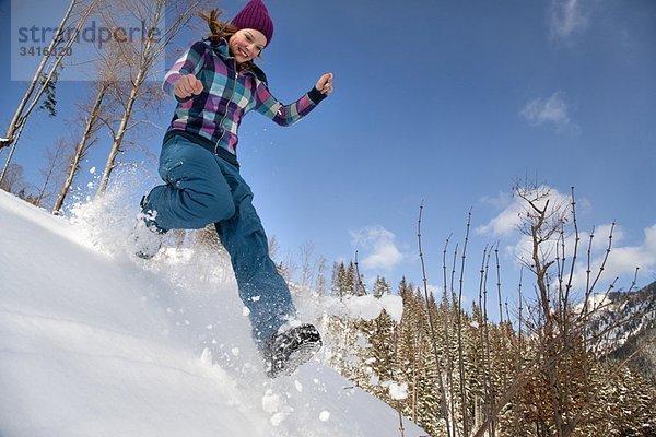 Mädchen springt  läuft im Schnee