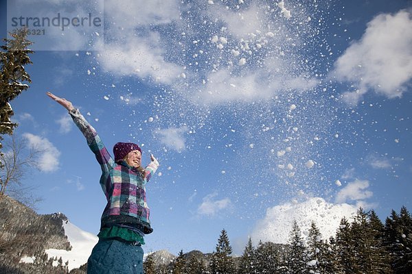 Mädchen wirft Schnee in die Luft