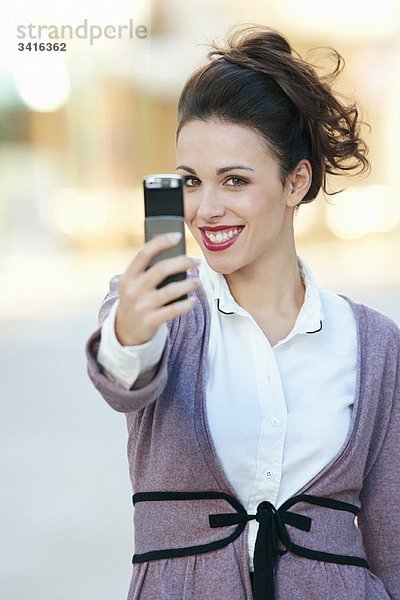 Eine Frau macht ein Foto auf ihrem Handy.