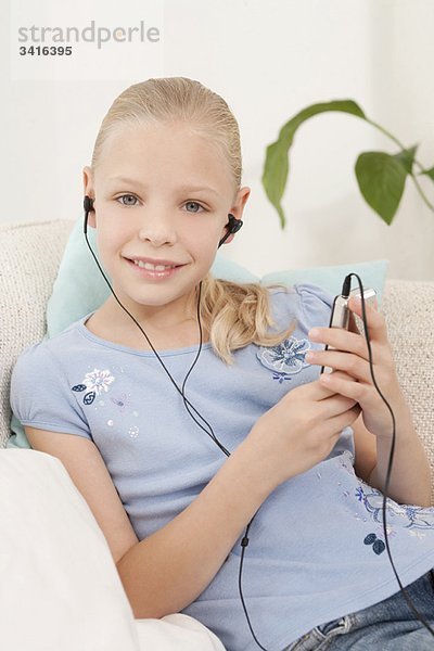 Ein Mädchen  das einen MP3-Player hört.