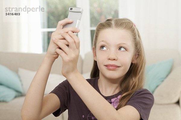 Ein Mädchen fotografiert auf dem Handy