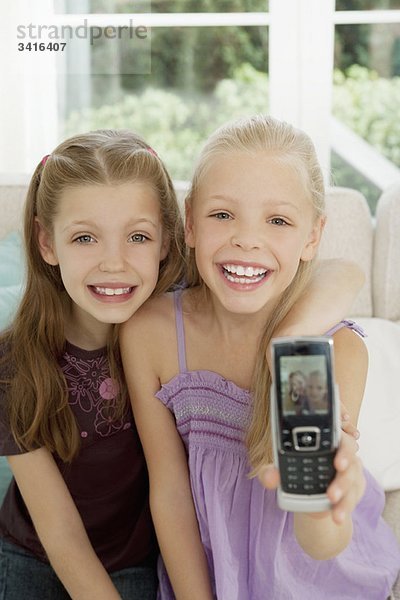 Zwei Mädchen zeigen ihr Bild auf einem Handy