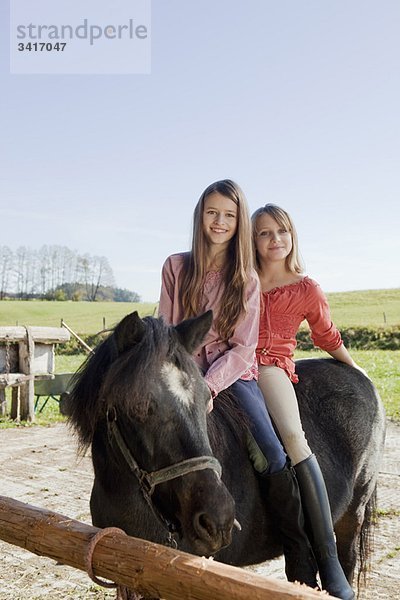Zwei Mädchen zu Pferd