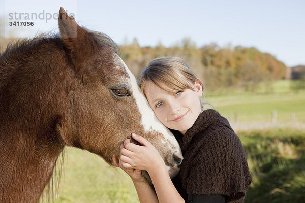 Mädchen beim Streicheln eines Pferdes