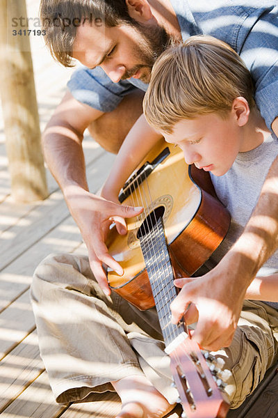 Vater und Sohn spielen Gitarre