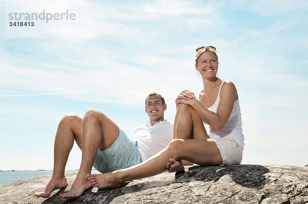 Junges Paar am Strand sitzend