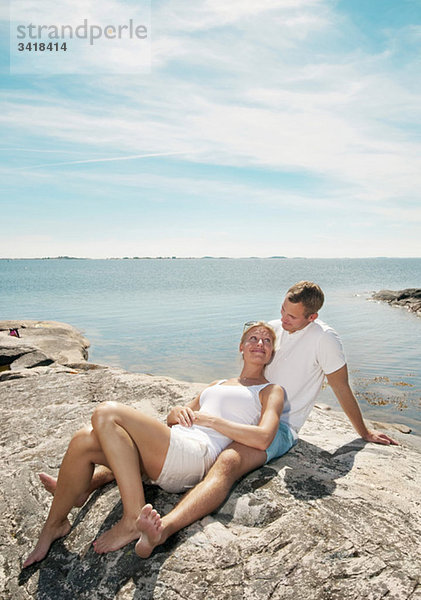 Junges Paar am Strand sitzend